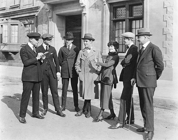Altes schwarz-weiss Bild mit einer Gruppe von Personen vor einer Bank